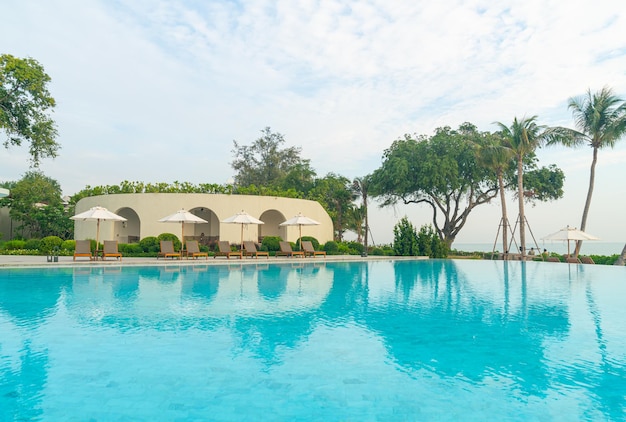 Umbrella with bed pool around swimming pool with ocean sea background