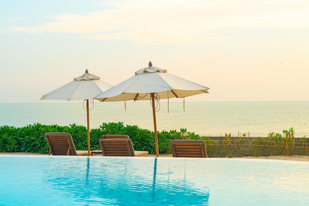 Umbrella with bed pool around swimming pool with ocean sea background