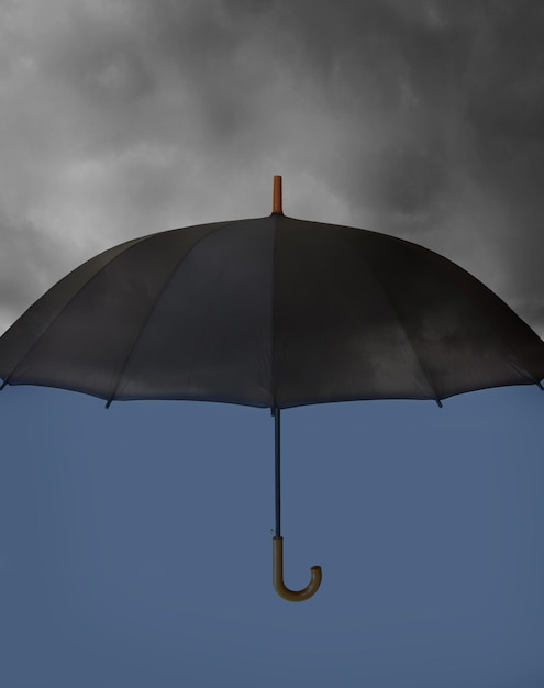 Umbrella with heavy clouds above and clear blue under