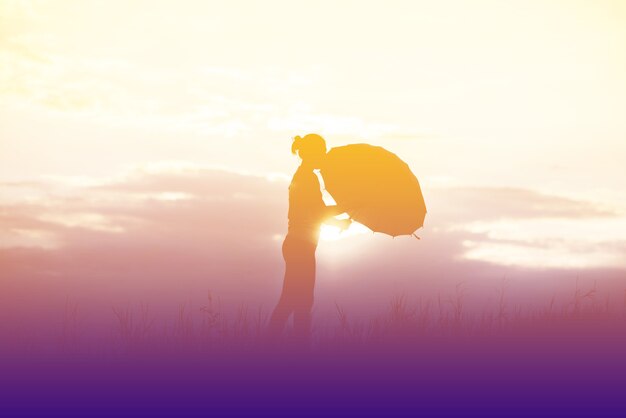 Photo umbrella woman and sunset silhouette