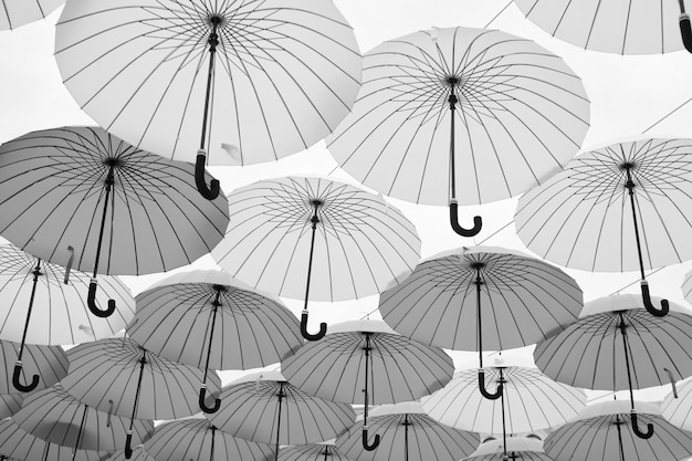 Umbrellas float in sky on sunny day Umbrella sky project installation Outdoor art design and decor Holiday and festival celebration Shade and protection