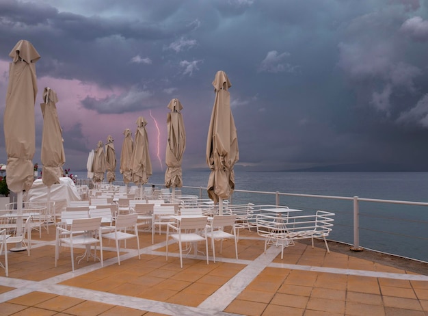 Umbrellas in a Greek tavern without visitors before a thunderstorm in Greece