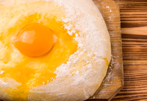 Uncooked dough with egg on a wooden table