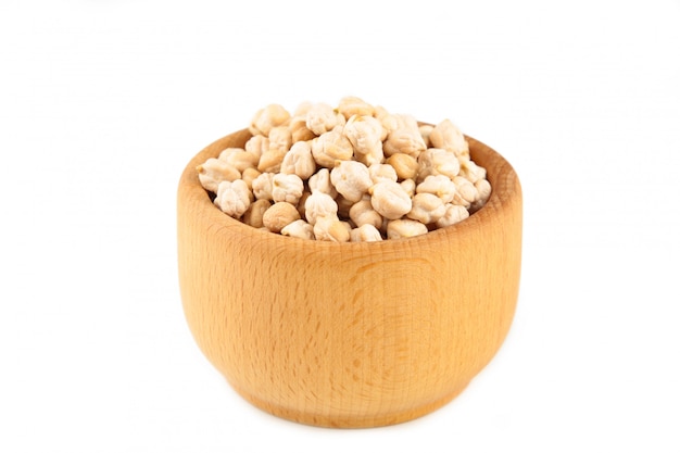 Uncooked dried chickpeas in wooden bowl isolated on white background