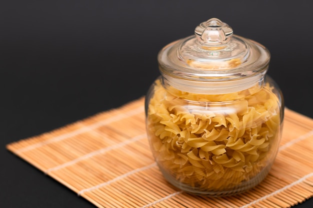 Uncooked fusilli pasta in glass jar