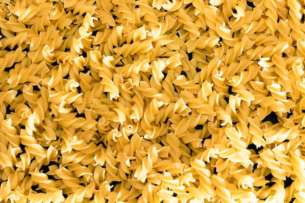 Uncooked fusilli pasta texture background