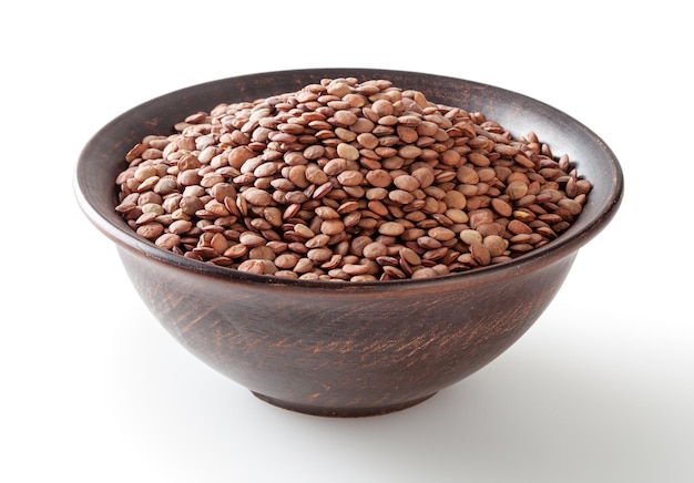 Uncooked green lentils in ceramic bowl isolated on white background with clipping path