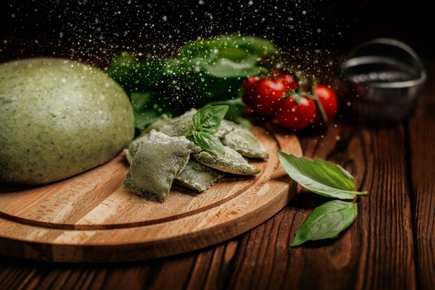 Uncooked green organic ravioli pasta handmade on kitchen table