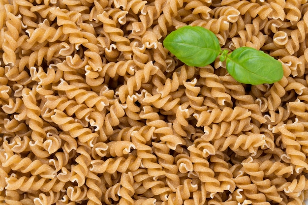 Uncooked wholemeal pasta isolated white background.