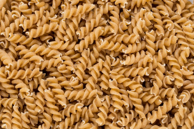 Uncooked wholemeal pasta isolated white background.