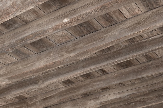 Underside view of an old wooden floor structure of a building damaged by woodworm holes