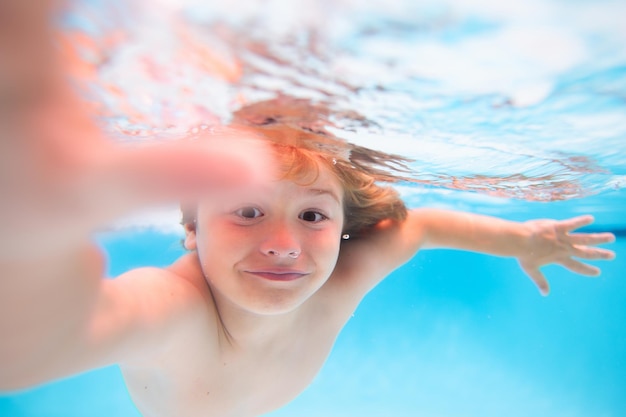 Underwater boy in the swimming pool cute kid boy swimming in pool under water