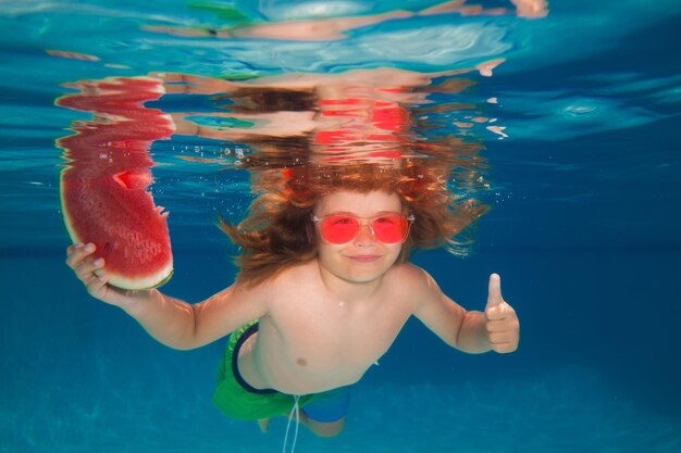 Underwater boy with watermelonin the swimming pool cute kid boy swimming in pool under water