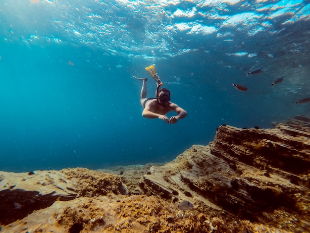 Underwater photo of men diver snorkeling in the sea water