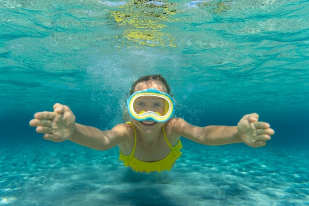 Underwater portrait of child Kid having fun in the sea Summer vacation and healthy lifestyle concept