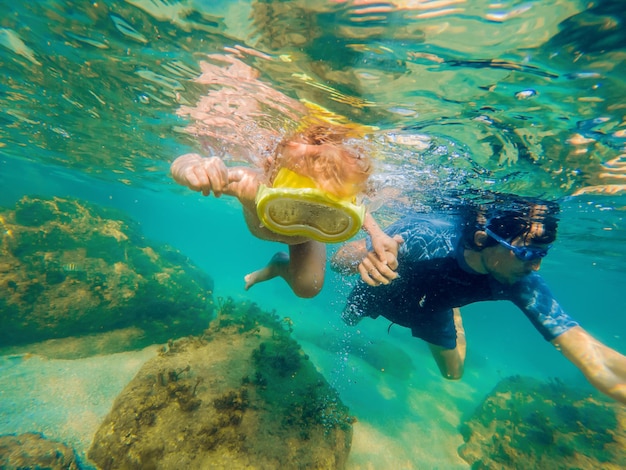 Underwater portrait of family snorkeling together at clear tropical ocean