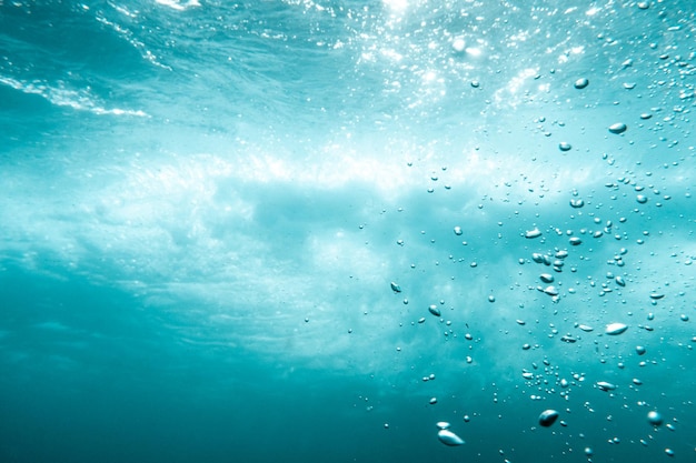 Underwater View of Bubbles In Deep Blue Ocean Close Up Water Background