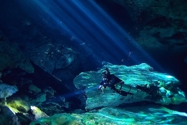 underwater world cave of yucatan cenote, dark landscape of stalactites underground, diver