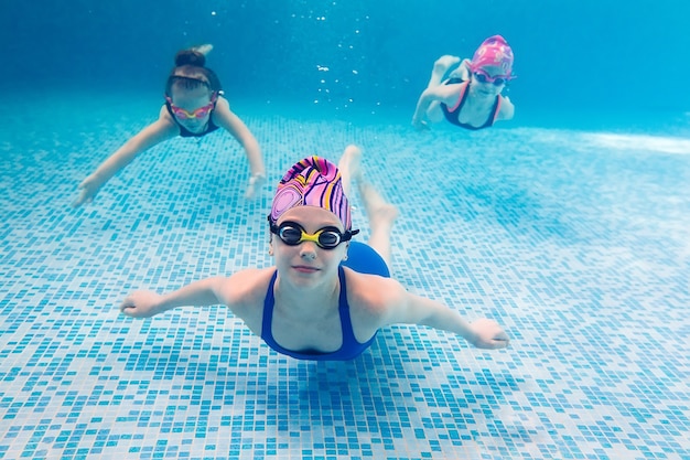 Underwater young friends in swimming pool