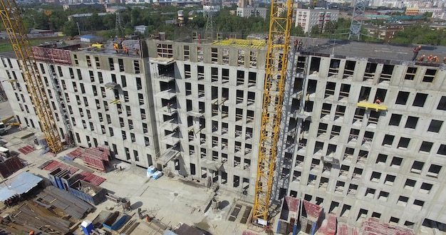 Unfinished apartment complex with builders on the top aerial