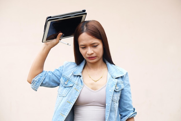 Unhappy Asian women using portable computers because the operating results have decreased profits