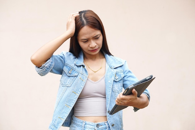 Unhappy Asian women using portable computers because the operating results have decreased profits