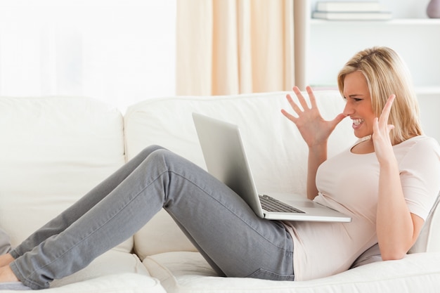 Unhappy blonde woman having trouble with her laptop