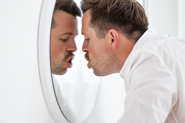 Unhappy businessman leaning on mirror trying to calm down