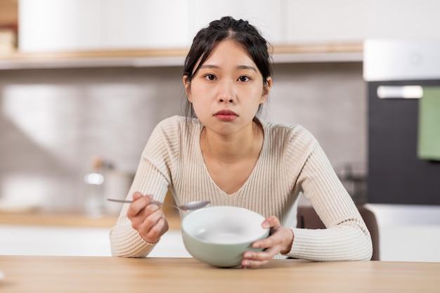 Unhappy chinese woman showing her empty plate