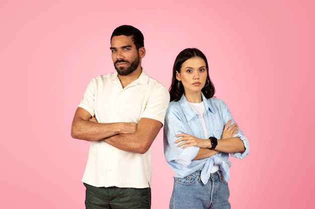 Unhappy frustrated young couple stand back to back pink background