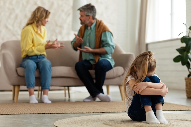 Unhappy Little Girl Suffering While Parents Having Quarrel Shouting Indoors