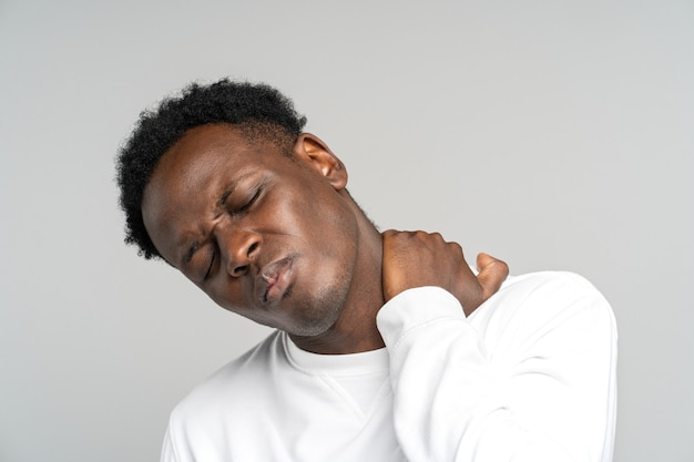 Unhappy man suffering from neck pain