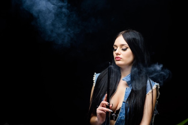 Unhealthy addiction Tabacco drug exhale smoke on black background Bad habit Woman vapor sexy woman smoking cigar hookah bar Electronic cigarette copy space like hookah