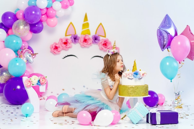 Unicorn girl posing near happy birthday cake idea for decoratin