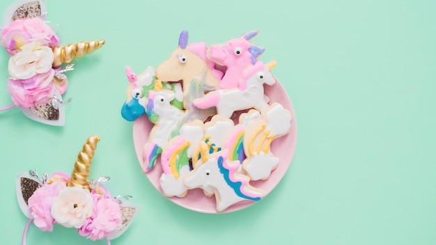 Unicorn shaped sugar cookies decorated with royal icing on pink plate.