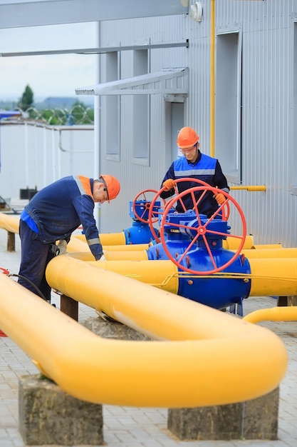 A uniformed worker opens a valve to control gases