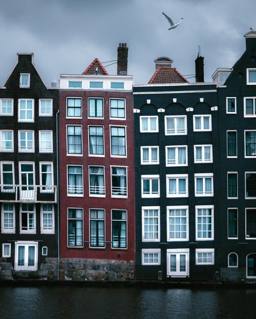 Photo the unique houses of damrak on a cloudy day found in the heart of the dutch capital of amsterdam