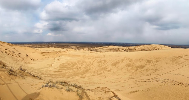 A unique sandy mountain in the Caucasus on a cloudy day Grass grows on a sand dune