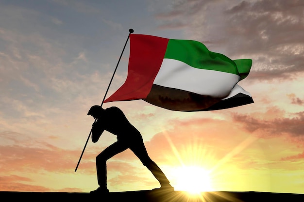 United Arab Emirates flag being pushed into the ground by a male silhouette 3D Rendering