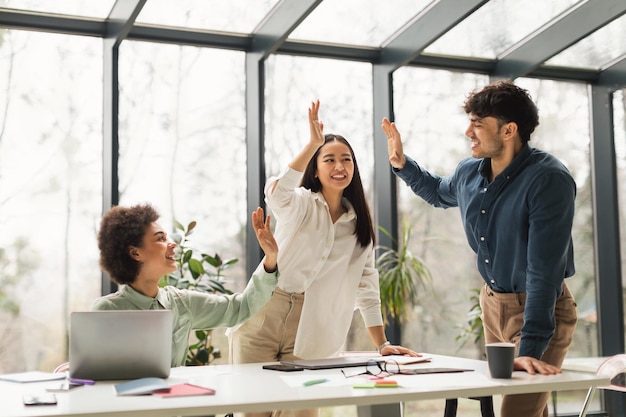 United business team giving high five celebrating success in office