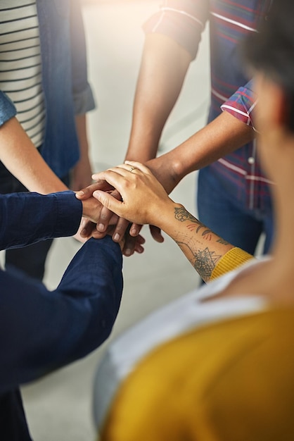 United in the name of creativity Shot of a team of unidentifiable creatives piling their hands together in the office