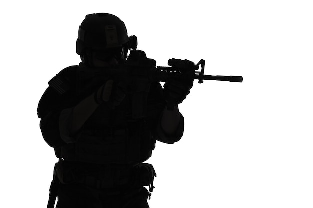 Photo united states marine corps special operations command marsoc raider with weapon aiming a gun. silhouette of marine special operator white background