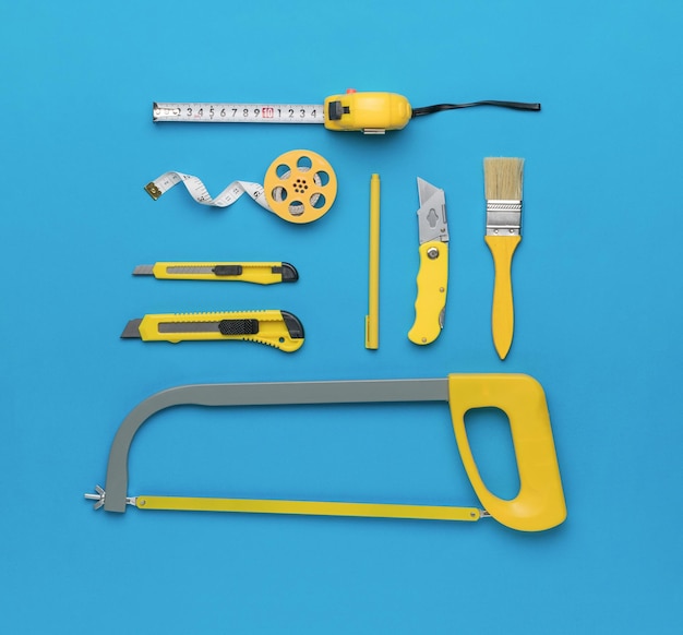 A universal large set of yellow tools on a blue background Flat lay