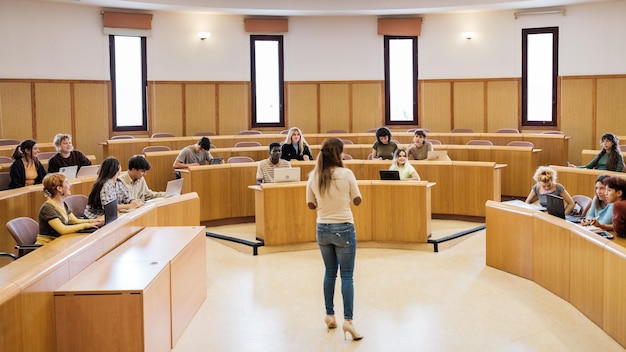 University class in a circular classroom with students of different origins and the teacher in the middle