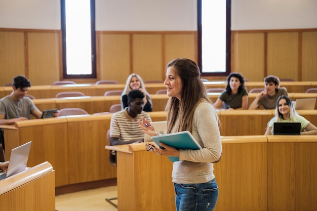 University professor explaining to her students in a circularshaped classroom at the faculty Concept students education teach