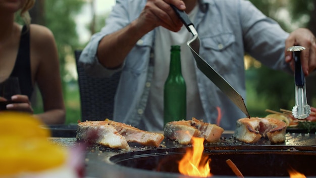 Unknown guy preparing bbq fish outside Man chef finishing cooking process