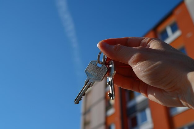 Unlocking Dreams Hand of a man or woman holding silver keys to a new apartment or flat