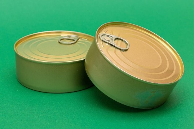 Unopened tin cans with blank edges on green background