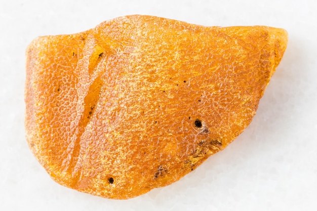 Unpeeled nugget of Amber gemstone on white