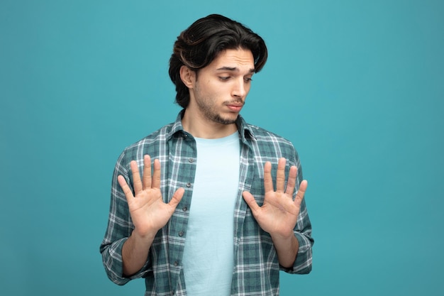 unpleased young handsome man looking at side showing no gesture isolated on blue background